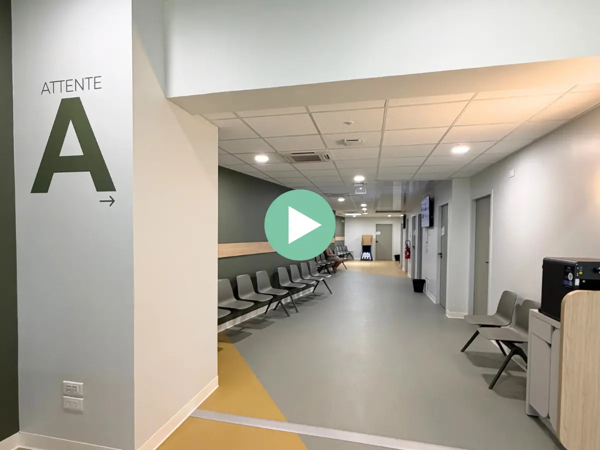 Salle d’attente A de l’Imagerie du Parc à Toulon, avec un pictogramme de lecture annonçant la vidéo de présentation du centre.